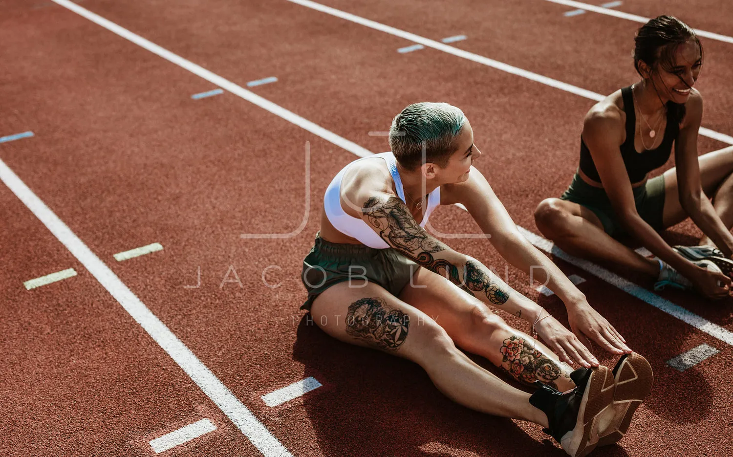 Athletes doing stretching exercises on running track